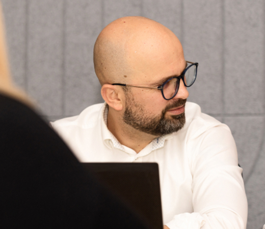 7N male staff member in a meeting with his computer open